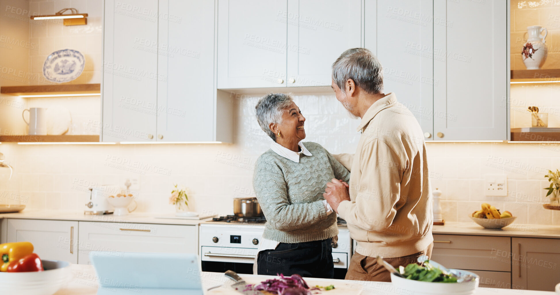 Buy stock photo Dancing, smile and senior couple in kitchen at house listening to music, playlist or radio together. Happy, love and elderly man with woman for moving to song for bonding, care and connection in home