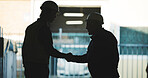 Construction, men and outdoor with handshake for deal, illegal agreement and collusion for extortion. Shadow, contractors and shaking hands at site for unethical practice or building compliance scam