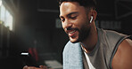 Happy, man and phone in gym with earphones, browsing fitness app and listen to online music playlist. Person, smile or exercise recovery in health club with audio tech, social media or search workout