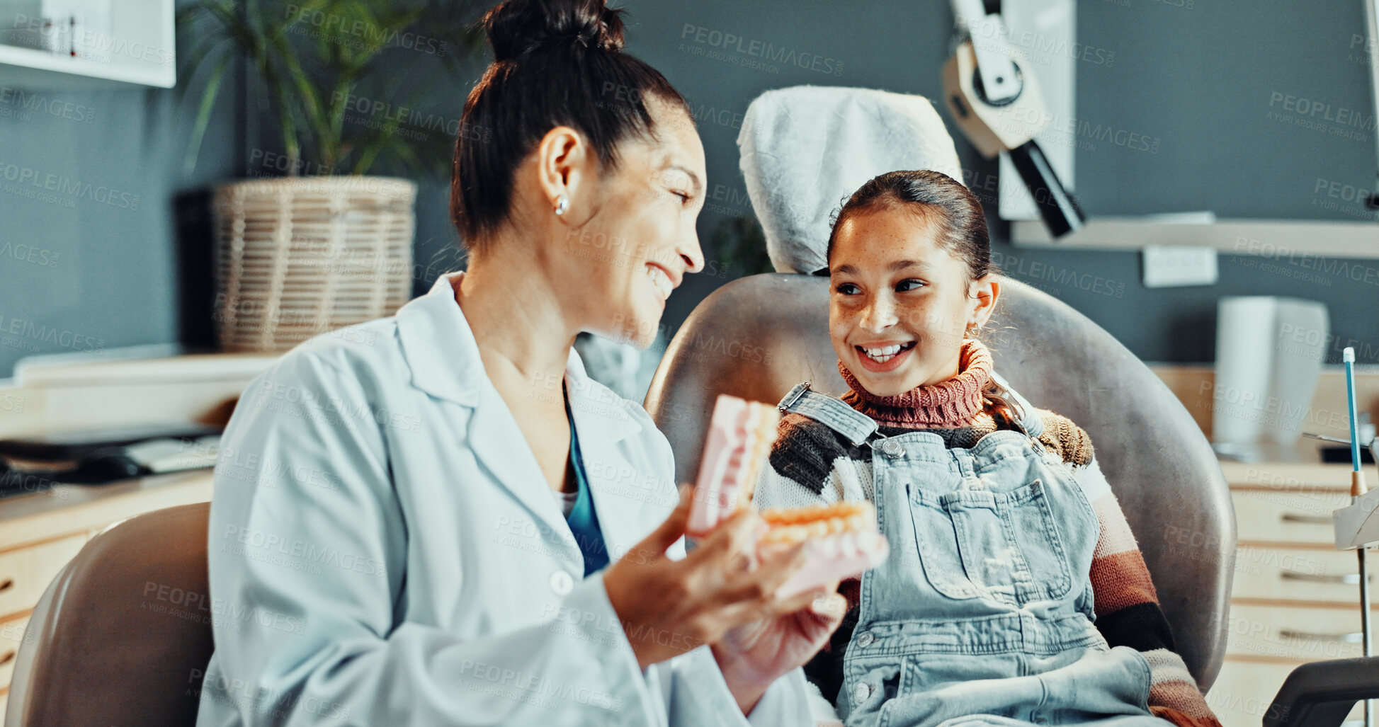 Buy stock photo Dentist, woman and tooth model with child, advice and appointment for checkup. Healthcare, explanation and consulting with happy girl kid for dental care, oral hygiene and cleaning service in clinic