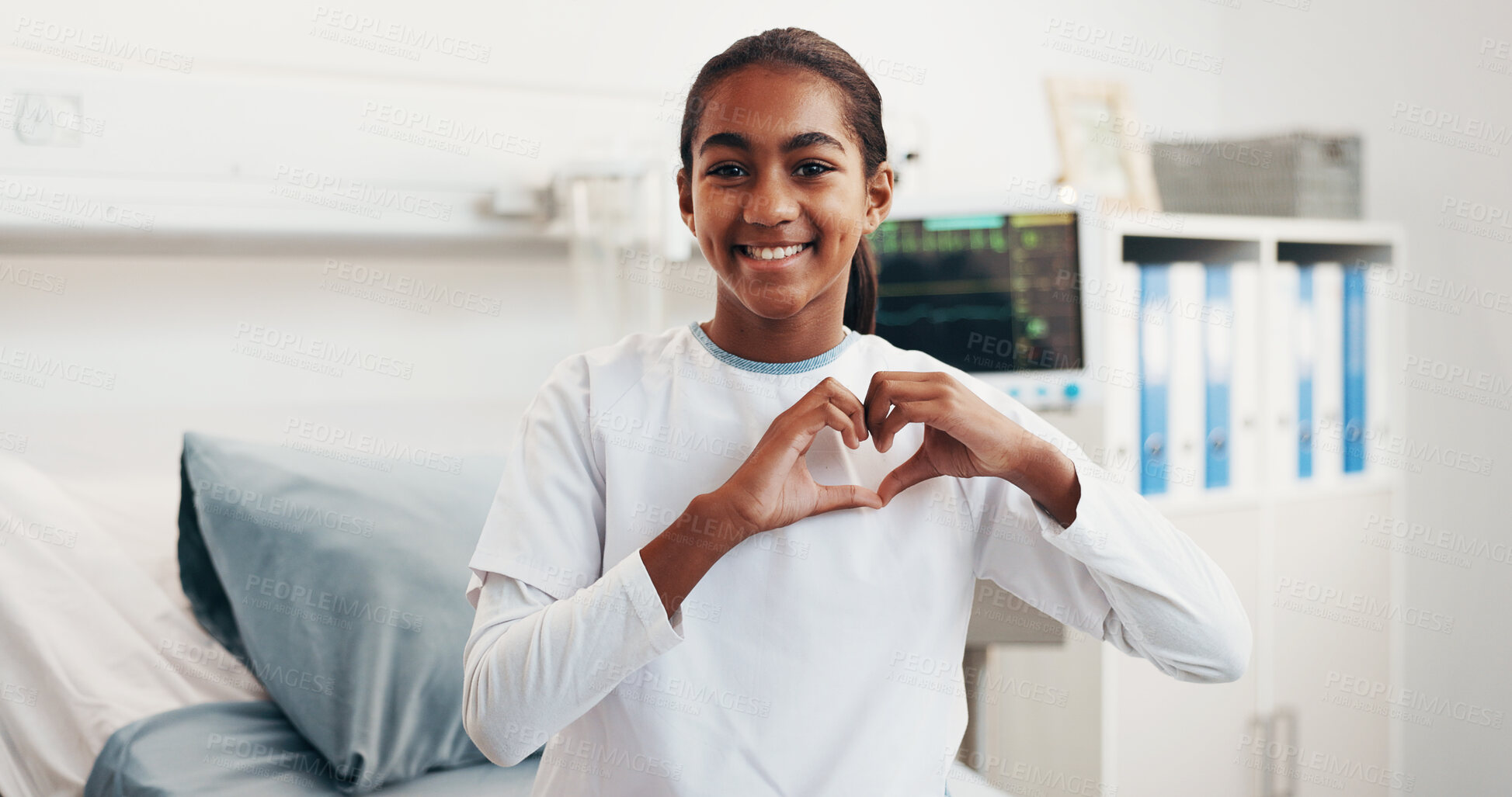 Buy stock photo Child, portrait and happy girl with heart hands in hospital bed for love or healthcare treatment. Kid, patient or smile with like emoji, shape or gesture for cardiology, medical support or trust