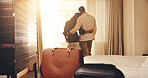 Couple, travel or hug with bag in bedroom for honeymoon trip, romantic getaway or accommodation. Back view, man and woman with window, embrace or luggage in hotel for weekend or holiday together