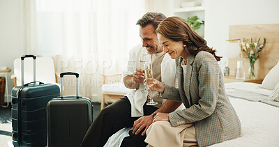Buy stock photo Couple, travel and cheers with champagne in hotel, laughing and celebration with partner in bedroom. Relationship, commitment and happy mature people with alcohol, toast and anniversary in motel