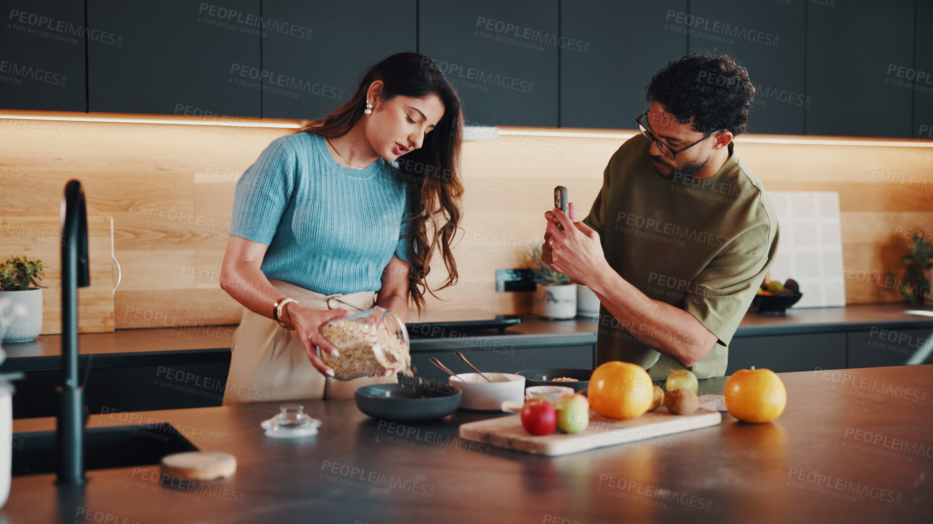 Buy stock photo Phone, couple or cooking breakfast with recording for tutorial, nutrition vlog or live streaming. Meal prep, woman and man with mobile in home kitchen, pour oats or morning food blog for healthy diet