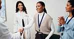 Woman, doctor and meeting with handshake for winning, team success or promotion in hospital. Happy, female person and shaking hands with colleagues or applause for congratulations in clinic boardroom