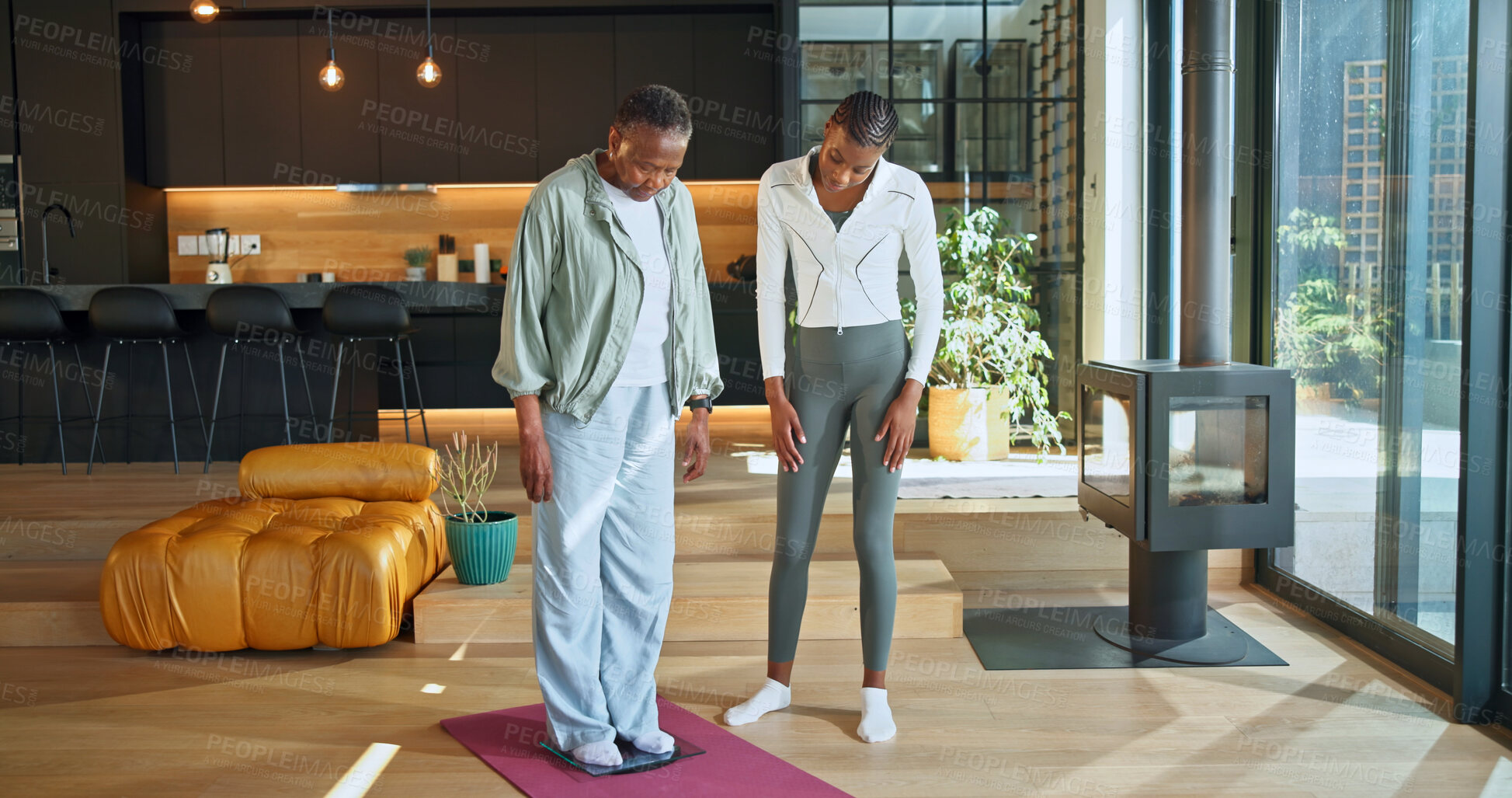 Buy stock photo Personal trainer, scale and fitness with black women in home for help, geriatric health and support. Exercise instructor, wellness and weight loss check with senior person for muscle tracking