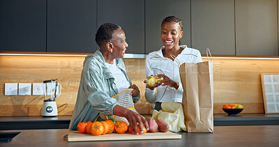 Buy stock photo Unpacking, grocery and woman with senior mother in kitchen, laughing and bonding together in house. Family, connection and black person with elderly parent, happiness and healthy food in apartment