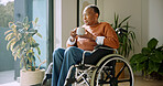 Tea, thinking and old woman by window with wheelchair, calm afternoon and remember memories of past. Coffee, reflection and senior black person with disability, nostalgia or vision in retirement home