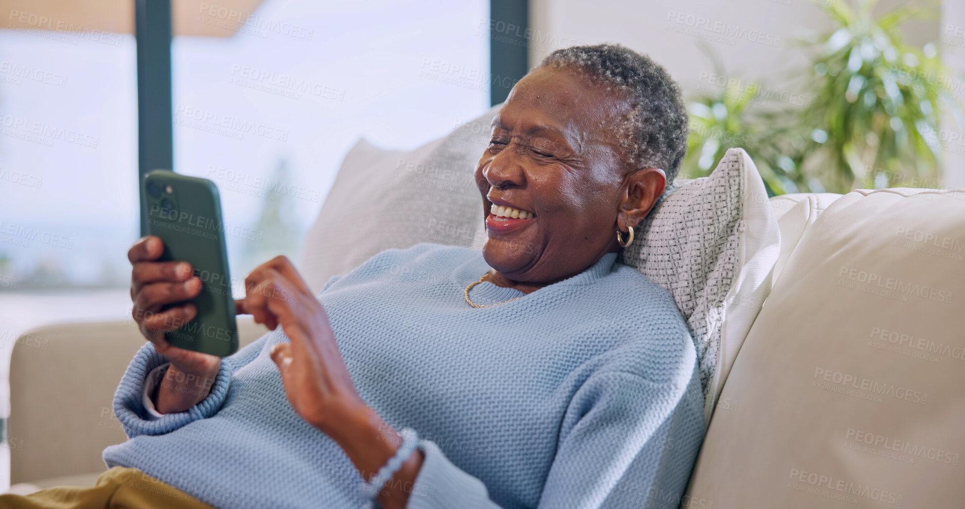 Buy stock photo Texting, online and old woman with phone in lounge, laugh and communication with contact on website. Retirement, home and senior black person with mobile, happiness and chat with social media app