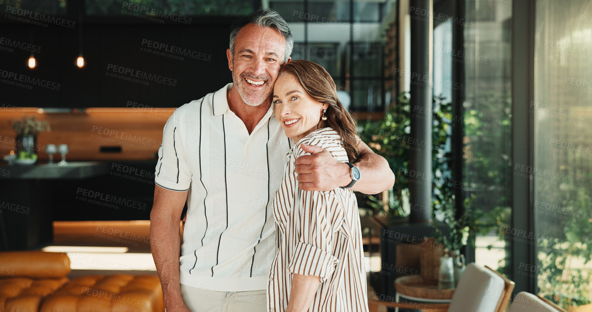 Buy stock photo Portrait, hug and mature couple in living room with smile, companion and bonding together on weekend. Happy, people and embrace in home with romantic relationship, wellness and support for partner.