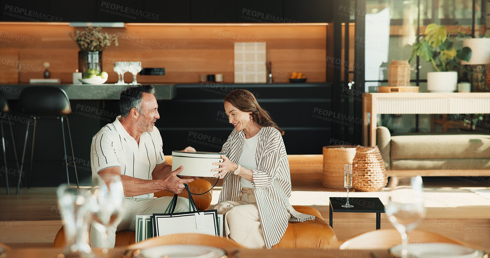 Buy stock photo Love, gift giving and mature couple in home, Christmas or gratitude for holiday celebration. Man, woman or appreciation with xmas present exchange, care or bonding together with happy partner on sofa