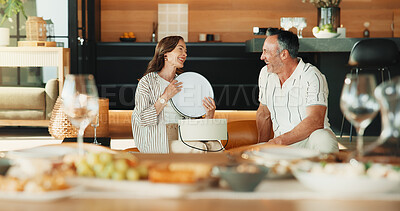 Buy stock photo Love, present and couple in house for thank you, laugh and anniversary celebration with smile. Mature man, woman and gift appreciation, gratitude or conversation with funny partner at romantic dinner
