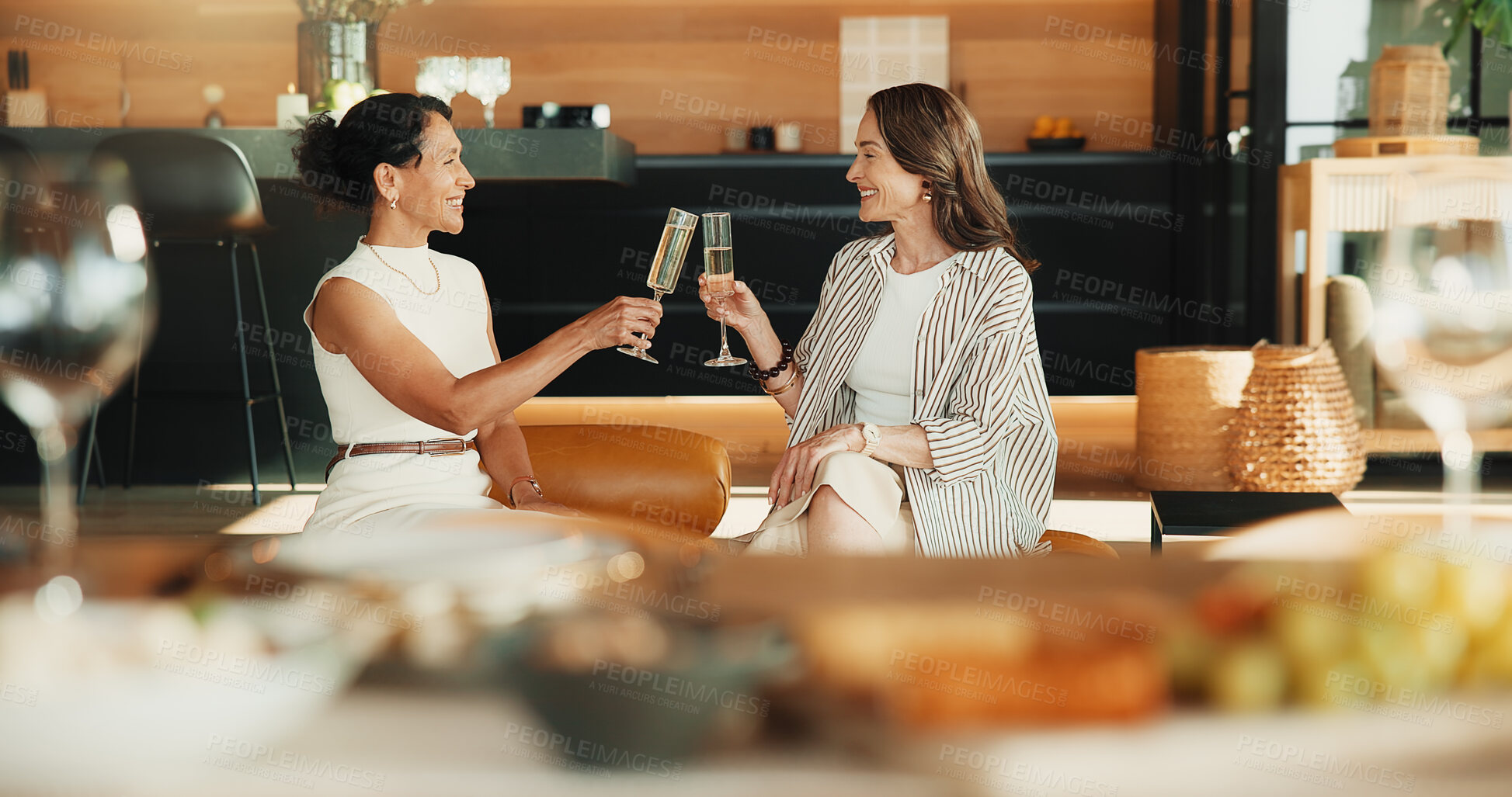 Buy stock photo Happy, friends and toast in home with champagne, bonding together or visit for connection on weekend. Mature women, relax and cheers in living room with alcohol drink, care and smile for friendship.