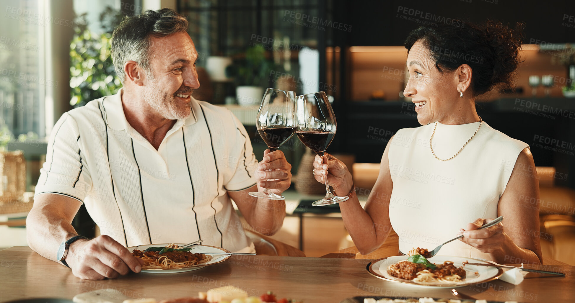Buy stock photo Couple, food or cheers with wine for love, relationship milestone or anniversary meal in home. Happy man, mature woman and toast with drink for appreciation, marriage care and lunch date with alcohol