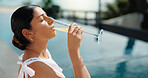 Woman, relax and vacation with drink by swimming pool for holiday getaway or outdoor summer break. Female person, glass or orange juice for zen, weekend travel or stress relief in luxury resort