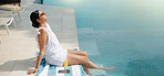 Woman, relax and vacation with swimming pool in resort for holiday getaway, travel or summer break. Female person, traveler or drink with sunglasses by poolside for weekend getaway trip in beauty spa