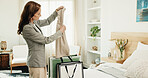 Woman, unpacking and shopping in home for fashion, clothing haul and purchase for retail therapy. Mature person, sorting and bags on bed with new outfit, collection and discount for wardrobe restock