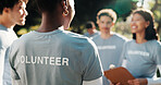 Volunteer, discussion or team in park with clipboard, task brief or guidance in charity project. Back, people or NGO group with collaboration, coordination or director checklist in outreach program.