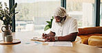 Remote work, home and black man writing on notebook for financial analysis, revenue planning or list. Freelancer, mature person and analyst with notes for investment chart, asset forecast or insight