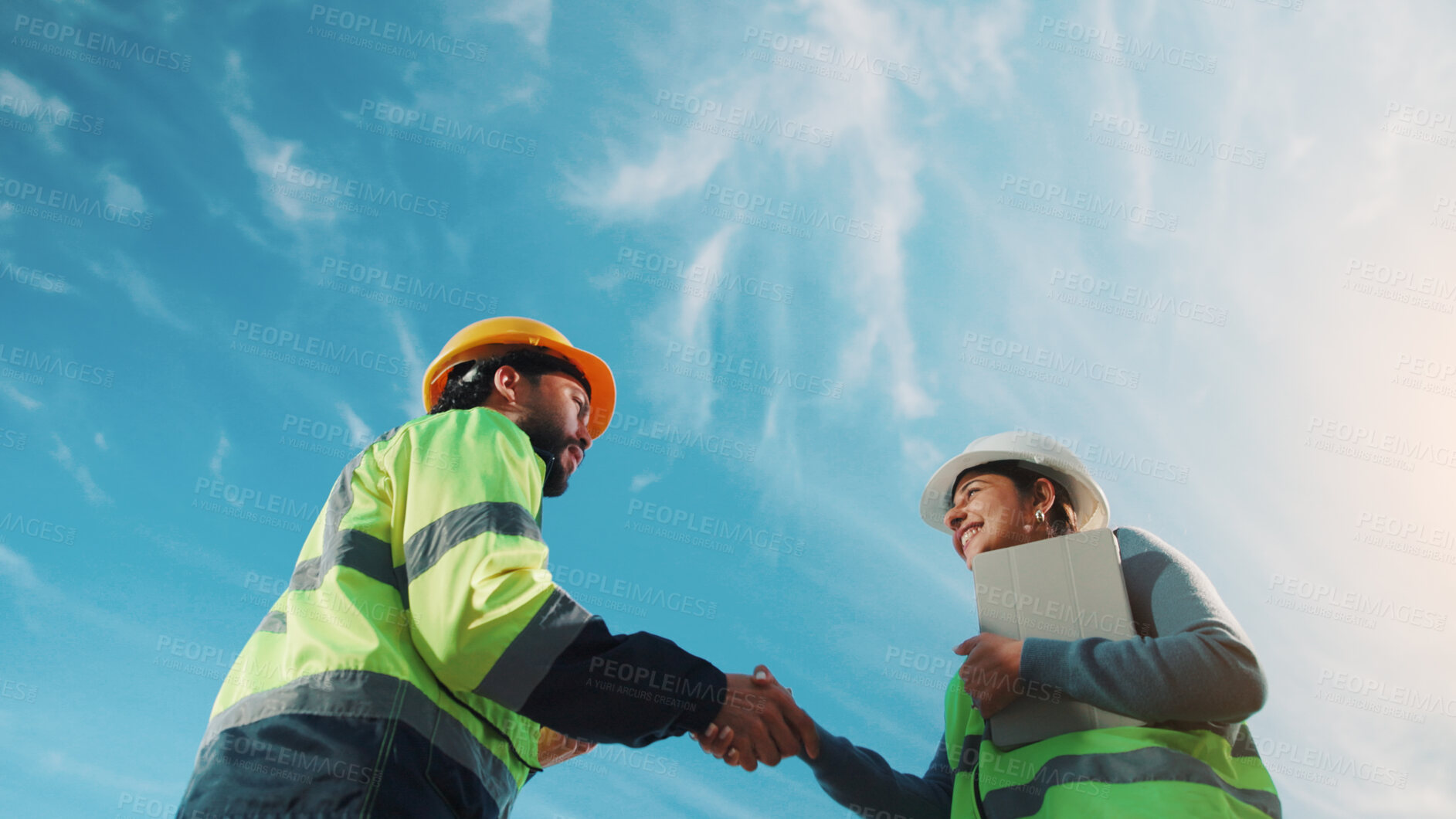 Buy stock photo Team, handshake and happy people with tablet on construction site, low angle and renovation project. Sky, mockup space and colleagues with tech for property development, collaboration or architecture