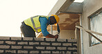 Man, building and tools at construction site with brick wall, manual labor and property development. Mature black person, builder and masonry outdoor with concrete, trowel and bricklaying for project