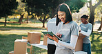 Volunteer, box and happy woman with tablet in park for outdoor donation, charity or outreach. Female person, activist or NGO with technology for community service campaign, app or checklist in nature