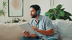Man, thinking and headphones or tablet on home sofa for streaming music, podcast or subscription. Idea, audio playlist and male person relax on couch with mobile app, technology and sound online