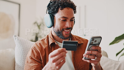 Buy stock photo Man, credit card and music or phone on home sofa for streaming, shopping or audio subscription. Happy, headphones and person relax on couch with online payment, technology and membership purchase