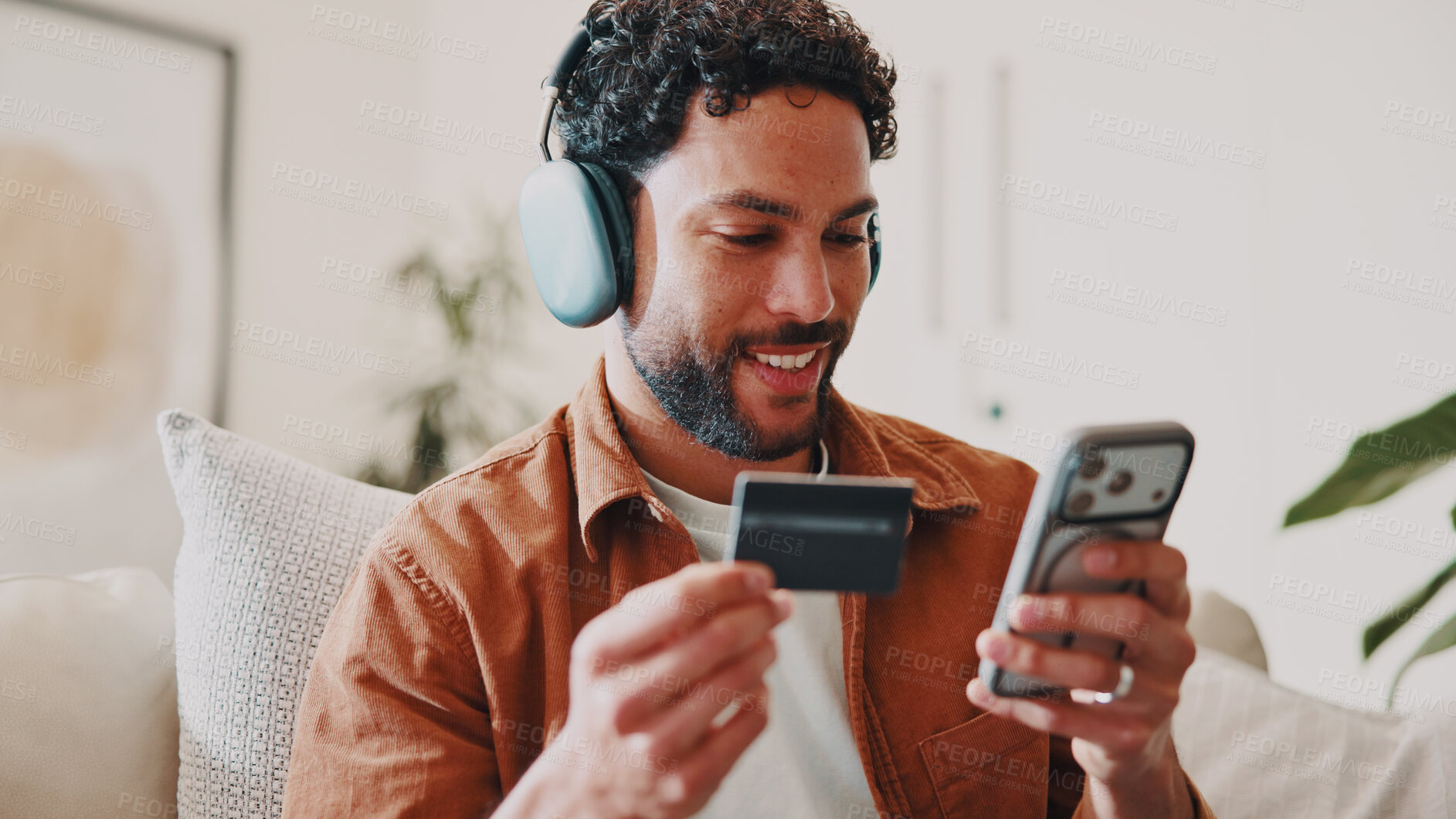 Buy stock photo Man, credit card and music or phone on home sofa for streaming, shopping or audio subscription. Happy, headphones and person relax on couch with online payment, technology and membership purchase