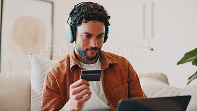 Buy stock photo Man, credit card and headphones or laptop on home sofa for streaming music, shopping or subscription. Happy, online movie and person relax on couch with payment, technology and membership purchase