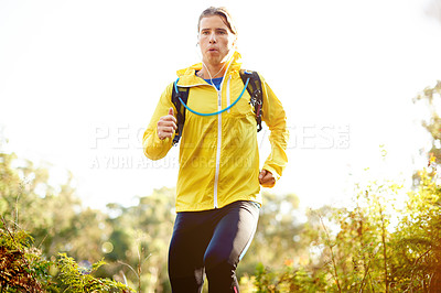 Buy stock photo Fitness, man and running with earphones in nature for marathon training, cardio podcast or breathing exercise. Runner, space and backpack on mountain trail for workout performance, music and playlist