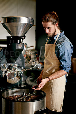 Buy stock photo Man, coffee beans and machine in roastery for roasting, flavor enhancing or inspection for distribution. Small business, master roaster and equipment in startup for quality control in export industry