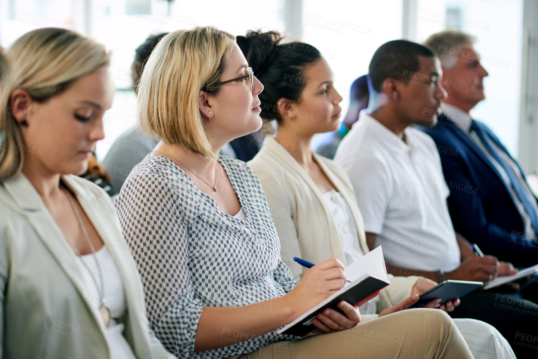 Buy stock photo Audience, business woman and notes at conference for presentation, training or attention. Seminar, convention and worker writing in notebook at company workshop for planning, insight or learning
