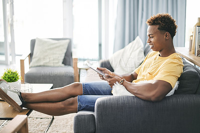 Buy stock photo Break, smile and tablet with man on sofa in living room of home to search for social media review. App, relax and weekend with happy person reading information online for me time planning or research