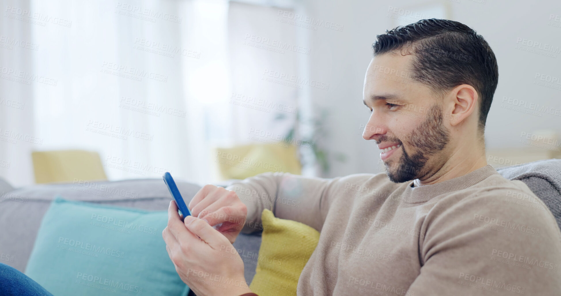 Buy stock photo Happy, man and scroll in home with phone, watch social media video and entertainment for good mood. Person, relax and browsing in living room with tech, smile and reading text message notification.