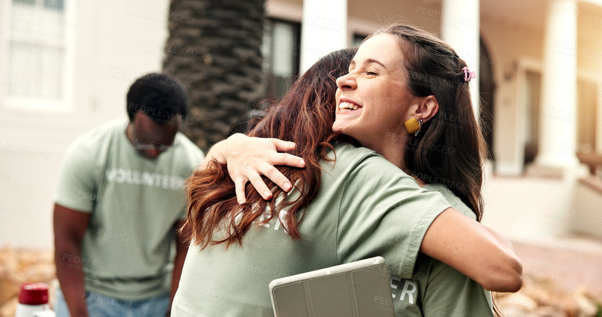 Buy stock photo Happy, woman and hug outdoor for volunteering, gratitude and thank you for community service. Smile, people and embrace with tablet for appreciation, recognition and team success of welfare project
