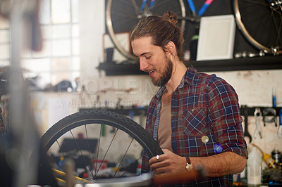 Buy stock photo Wheel, fixing or man with bike in workshop or store for repair, maintenance or upgrade. Small business, warehouse or male mechanic in garage for bicycle parts, mechanical engineering or tyre change