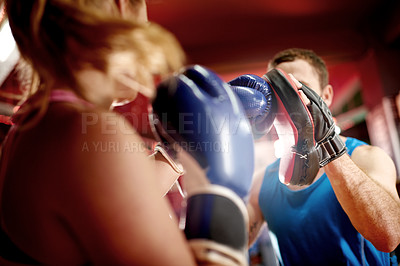 Buy stock photo Pad, learning or woman with coach for boxing exercise, strong punch or self defense gym. Fighting, people or boxer in sports practice for teaching technique or fitness workout with personal trainer