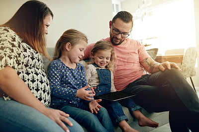 Buy stock photo Parents, children and tablet on sofa with smile, bonding and play games for challenge in family home. People, mom and dad with girl kids, tech or happy with app for puzzle, fun and love at house