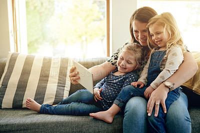 Buy stock photo Mom, girls and tablet on sofa with smile, love and together for video, cartoons and relax in home. Woman, children and digital tech for social media, games or movies in living room in family house