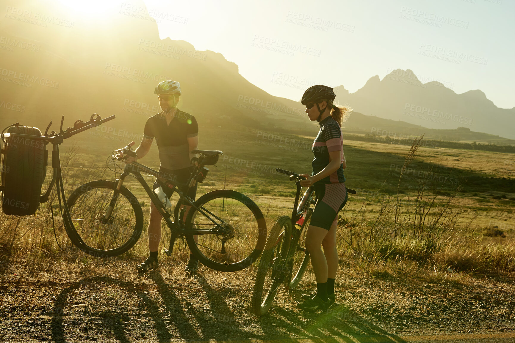 Buy stock photo Shot of a man and woman riding their bicycles in the countryside