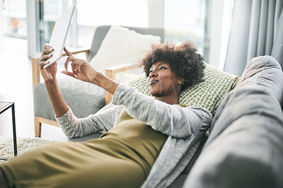 Buy stock photo Tablet, relax and smile with black woman on sofa for social media, connection and communication. Reading, networking app and streaming with person in living room of home for digital post and scroll