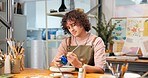Man, painting and clay cup in art studio, creativity and ceramic craft with color in workspace. Paintbrush, artistic process and male person with handmade project, artwork and skill development
