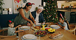 Christmas, parents and kids with chicken for serving, festive feast or holiday celebration in home. Interracial people, happy children and cut meat for xmas food, bonding or family tradition at table
