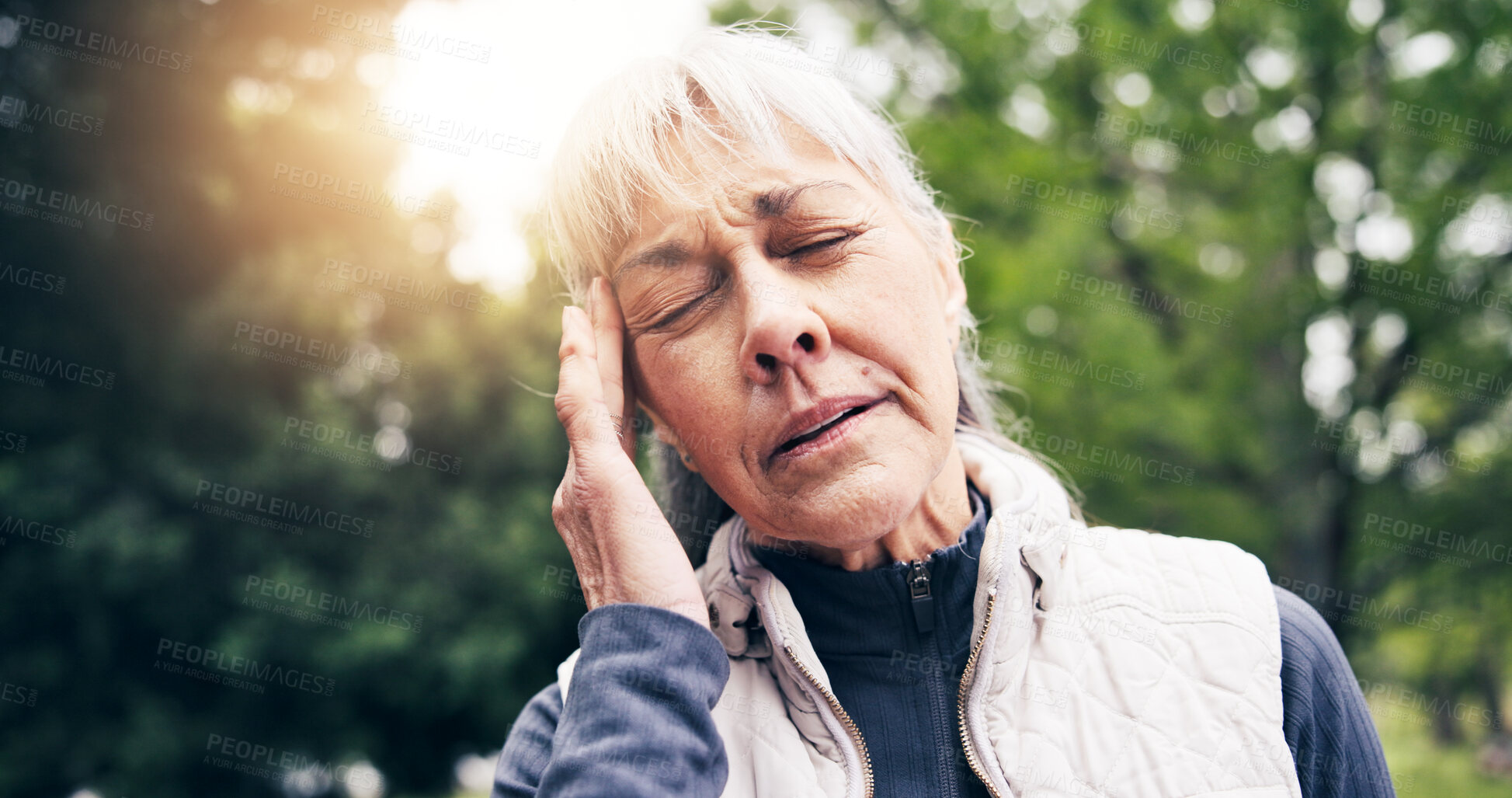 Buy stock photo Senior, woman and fitness with headache in park for outdoor strain, fatigue or mental health. Active, elderly or female person with sore head, migraine or lens flare in nature for workout or pressure