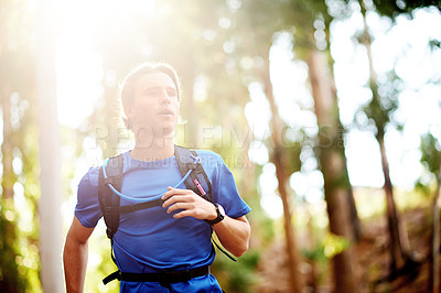 Buy stock photo Man, fitness and running with forest for workout, exercise or cardio in nature or woods. Male person, active or runner with backpack, trees or space for heart health, wellness or sport on trail