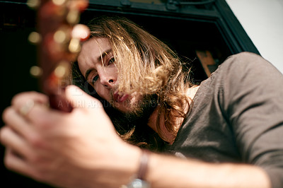 Buy stock photo Artist, music and man with guitar in home with tuning instrument, skills or practice. Playing, rehearsal and male person with acoustic strings for song with talent, hobby or activity from below.