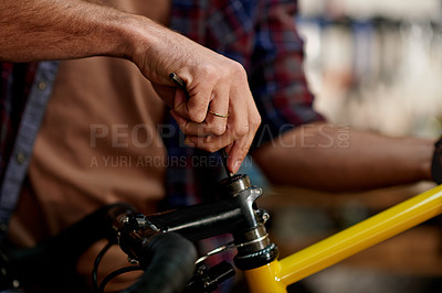 Buy stock photo Hands, repair and man fixing bicycle with spanner in garage for maintenance on wheels, chain or frame. Small business, service and male mechanic with tightening mechanical part on bike at workshop.