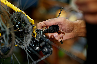 Buy stock photo Hands, man and repair a bicycle drivetrain in workshop for cycling safety, maintenance or fix damage. Bike mechanic, person and fasten gears with chain tool for ride performance or efficient shifting