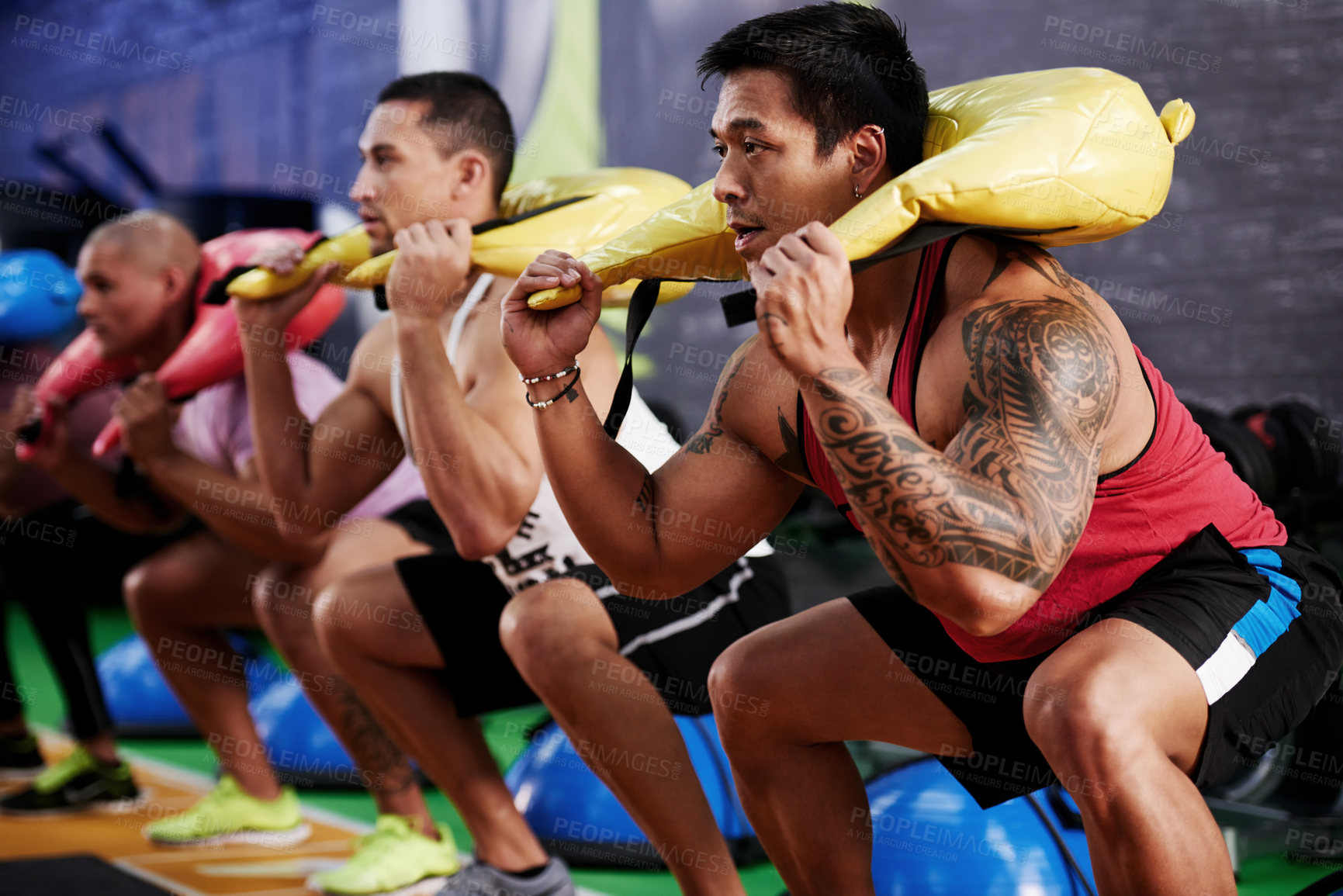 Buy stock photo Class, squat and people with sand bag exercise for training  session, legs workout or core strength. Athletes, teamwork and group of men with weight equipment for fitness, body health or gym support